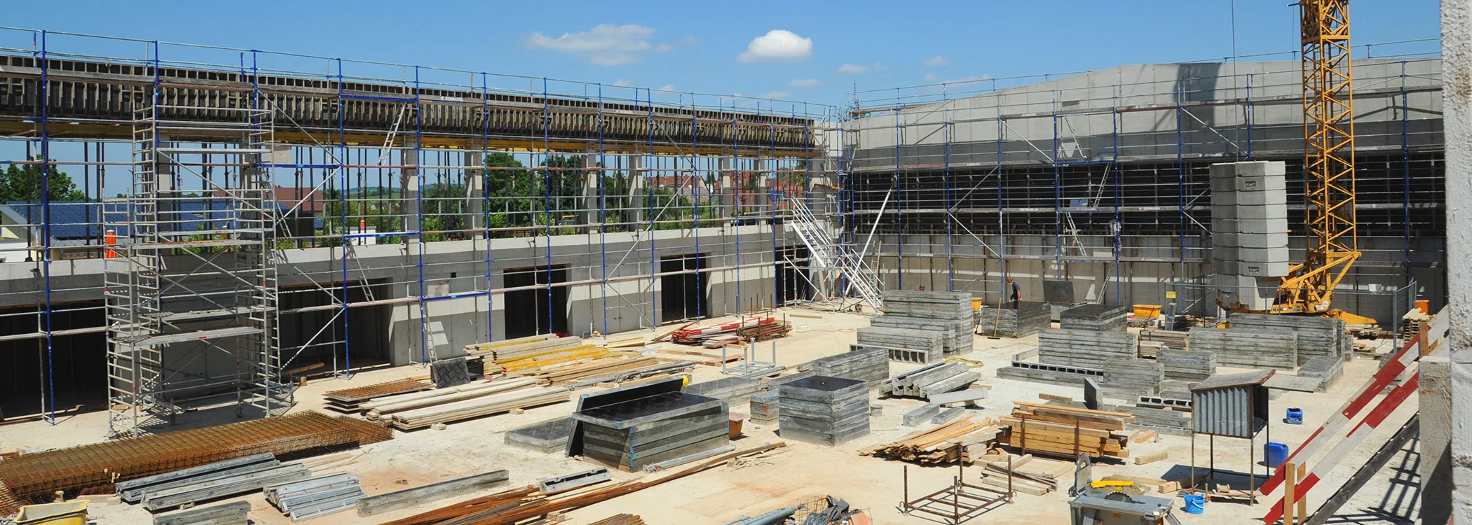 Großbaustelle mit gelagerten Schalungselementen, Gerüsten und Kran