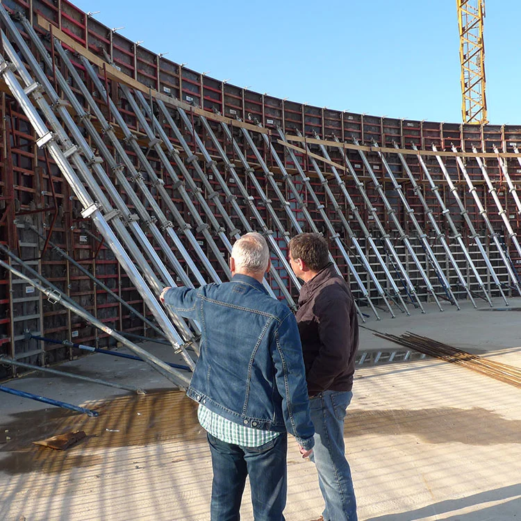 Zwei Männer von hinten vor einer gebogenen Wandschalung auf der Baustelle