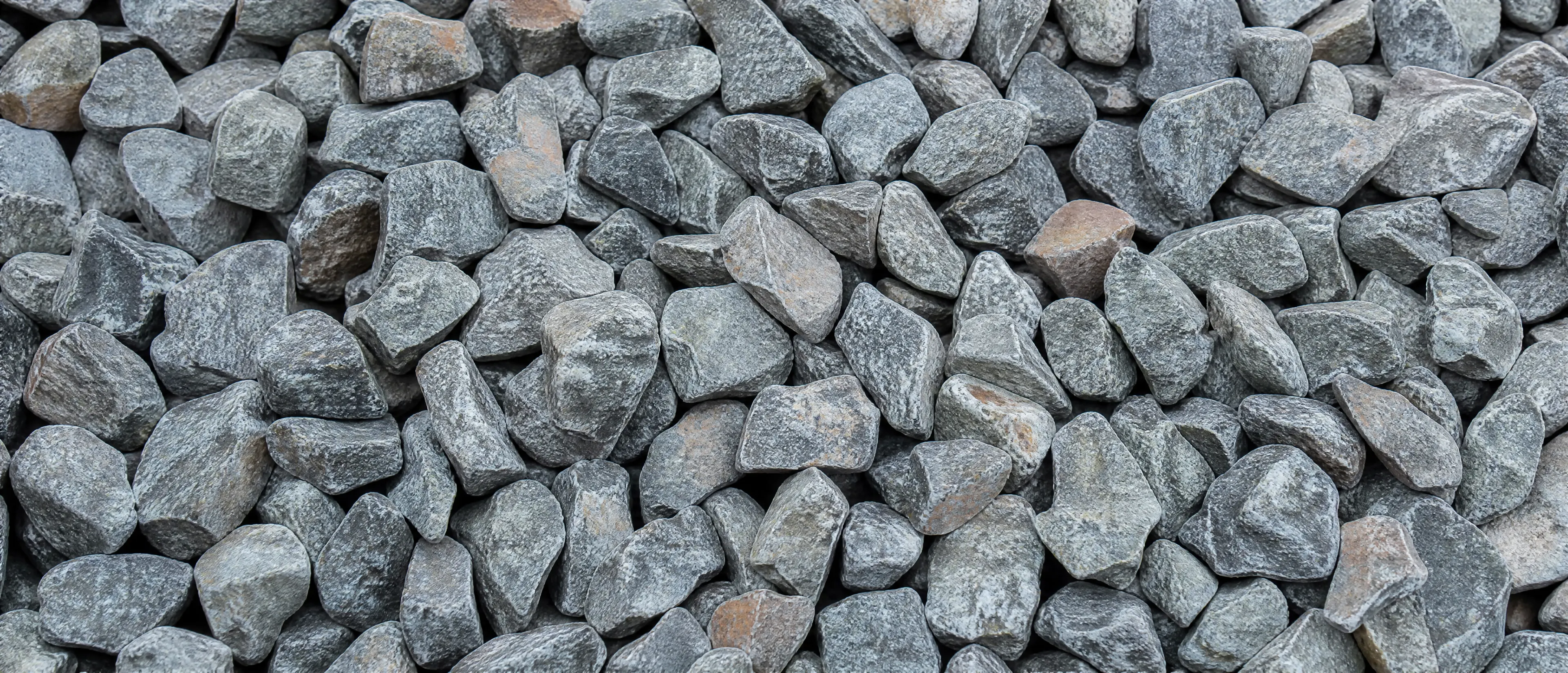 Grober grauer Gleisschotter aus Granit in Nahaufnahme